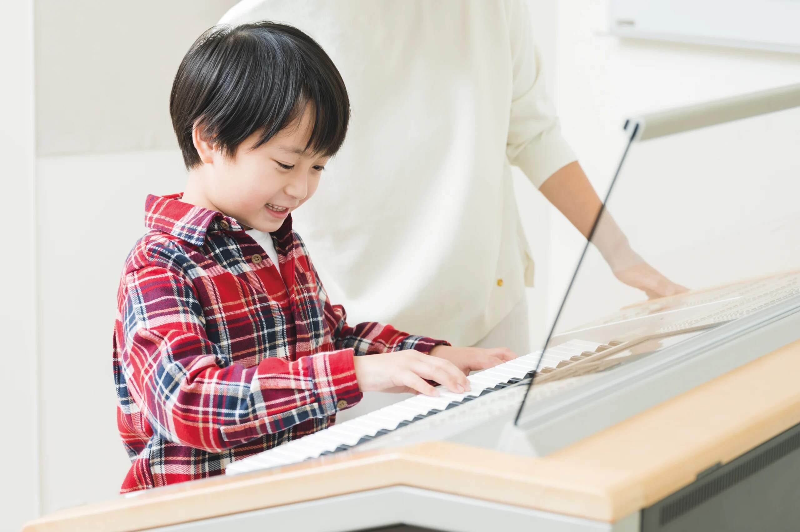 Happy young boy playing an Electone keyboard during a fun Yamaha Music School lesson – hands-on musical learning
                                for kids.