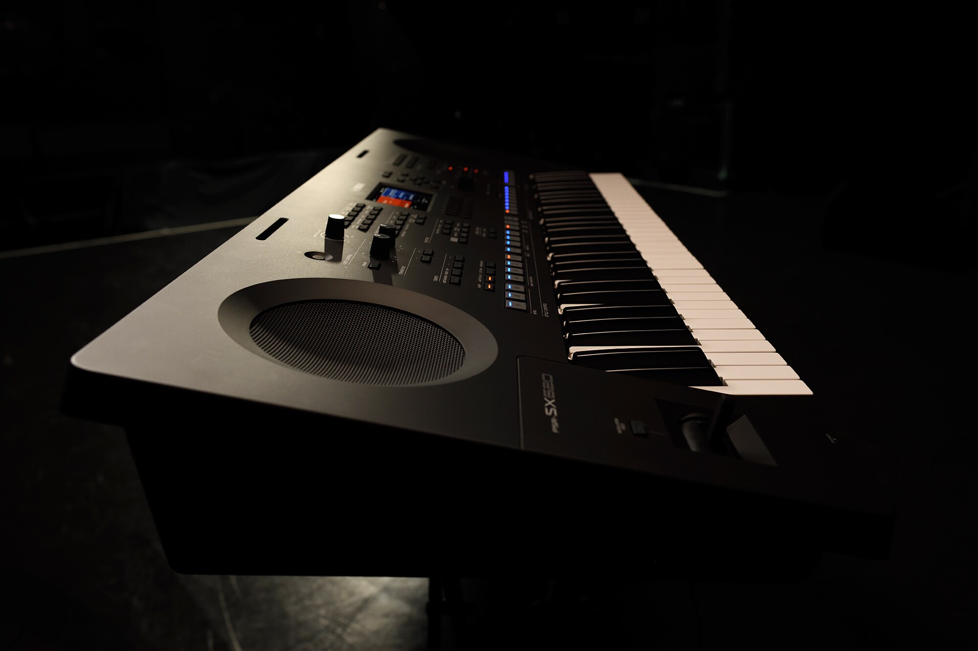 Keyboard di atas dudukan di bawah pencahayaan panggung