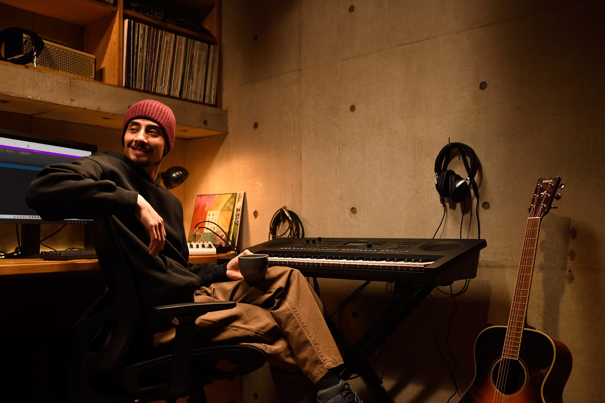 Ruang kerja musik rumah dengan komputer dan keyboard, yang menampilkan seorang keyboardis yang sedang bekerja di studio rumahnya