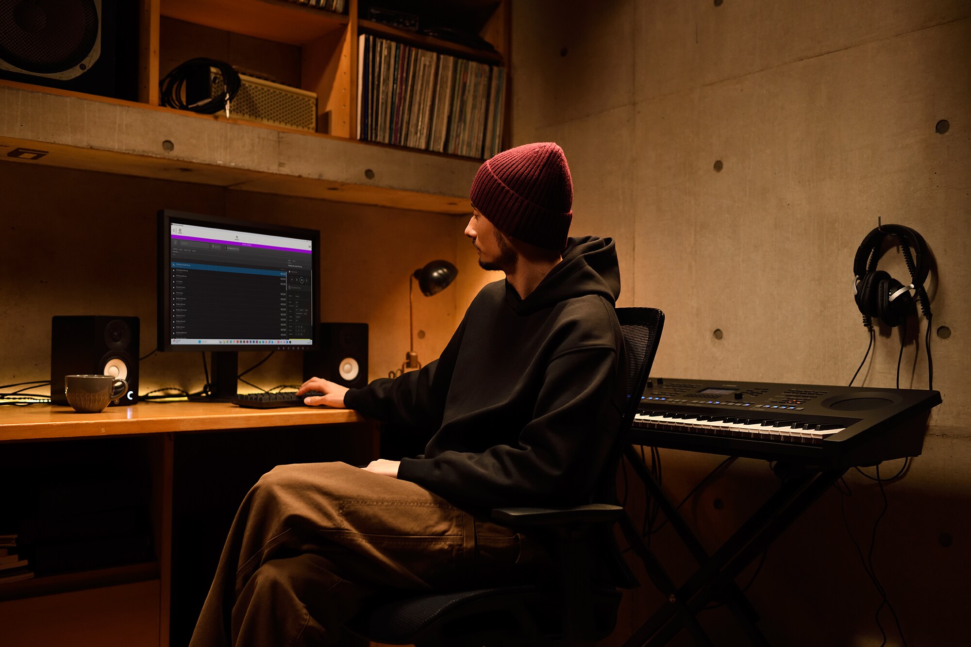 Ruang kerja musik rumah dengan komputer dan keyboard, yang menampilkan seorang keyboardis yang sedang bekerja di studio rumahnya