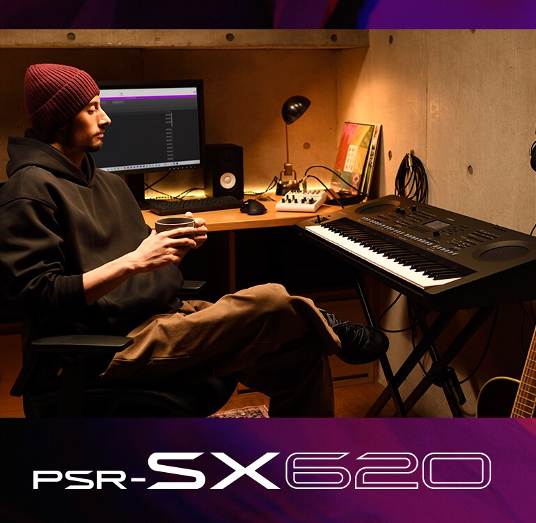 Seseorang duduk di depan keyboard PSR-SX di studio rumah, sambil minum kopi.