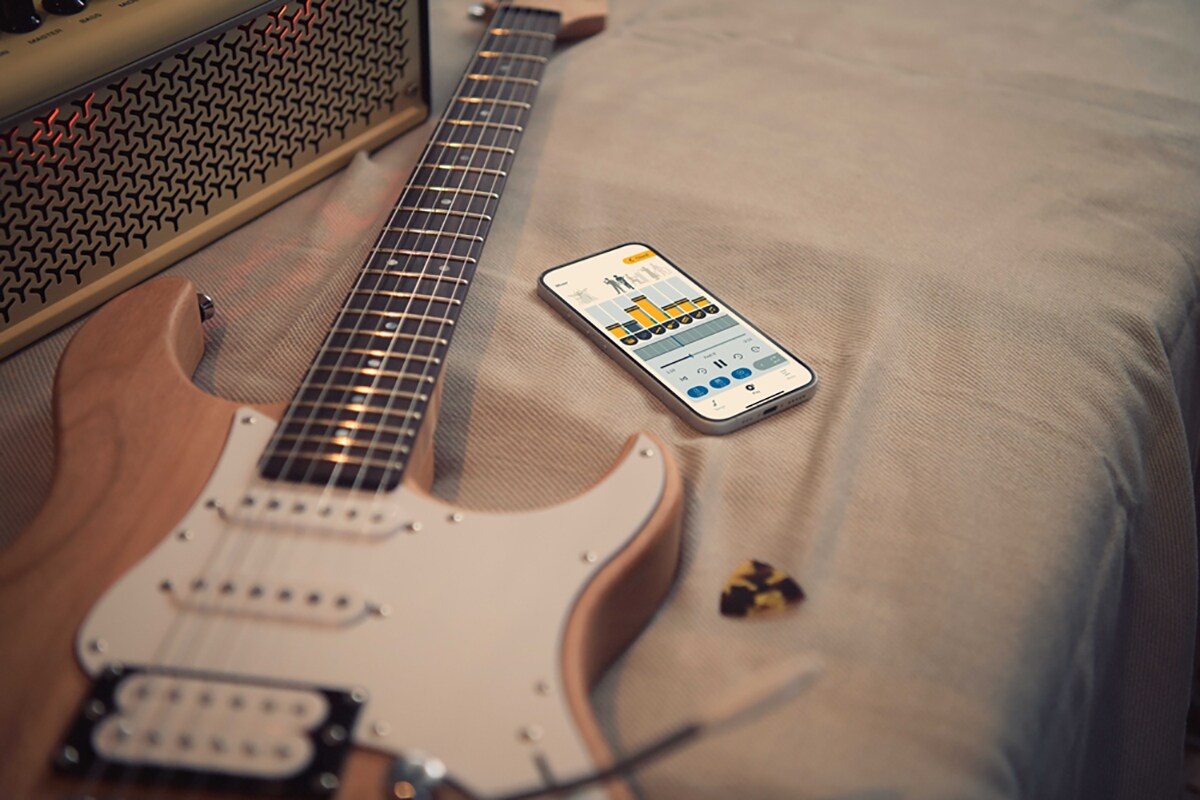 Aplikasi latihan musik Extrack di dekat gitar listrik dan penguat