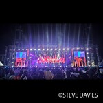 Tampilan  luas The Experience 2025 di Lagos, Nigeria, yang menampilkan  panggung  outdoor besar dengan pencahayaan dan layar video, di hadapan  ribuan jemaat  dalam acara musik gospel tahunan tersebut.